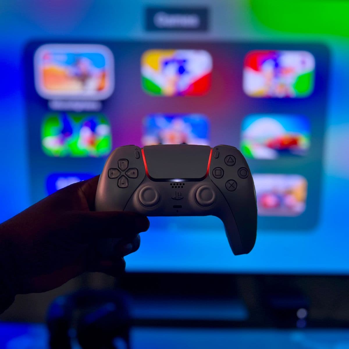 A player at a neon-lit gaming setup, controller in hand